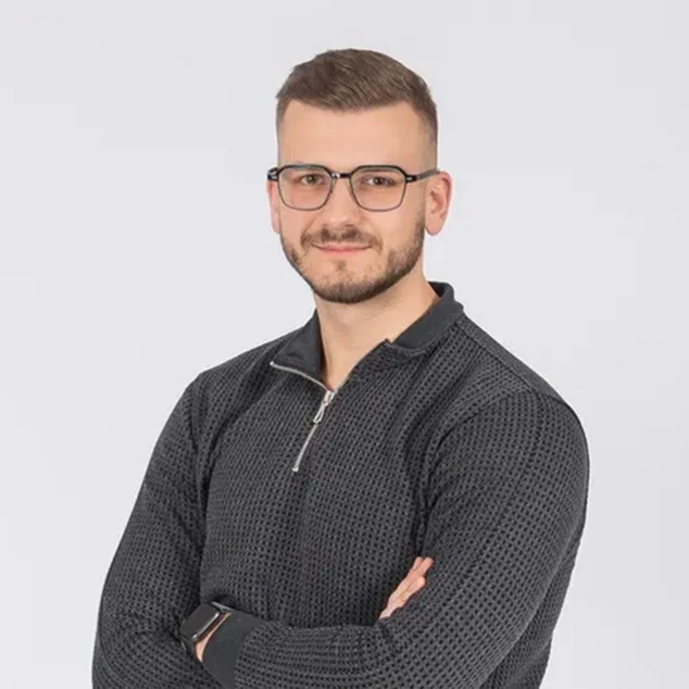 Tomislav Lazar, developer and founder of slikaj.hr, portrait in a grey sweater on a white background.
